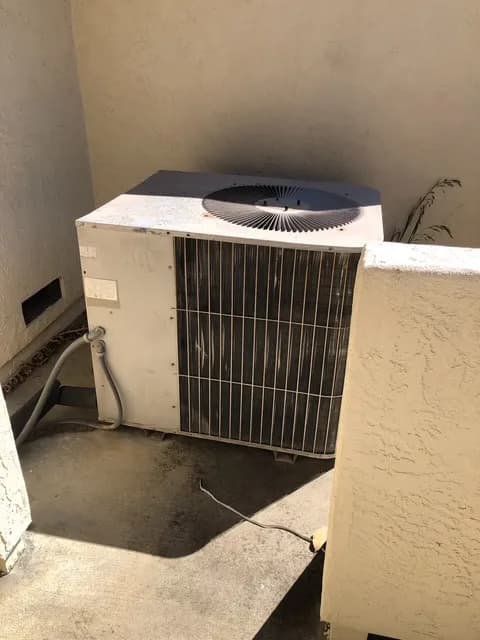 Old outdoor AC condenser unit before professional replacement